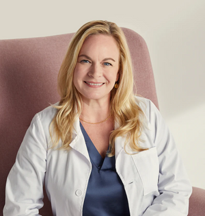 female doctor smiling white coat healthcare professional