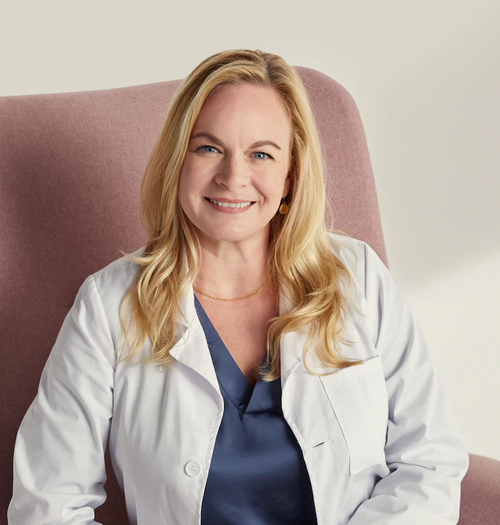 female doctor smiling white coat healthcare professional